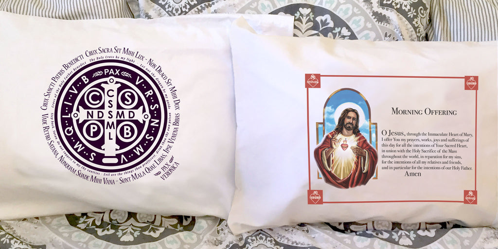 The Catholic St. Benedict medal image and prayer on a pillowcase and the Morning Offering to Jesus prayer on a white pillowcase.